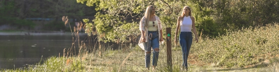 Two women walking down a trail.